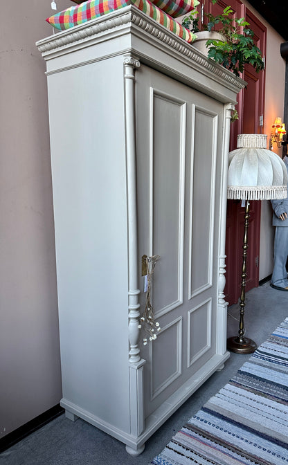 Greiget linneskåp med 1 dörr . foto från sidan