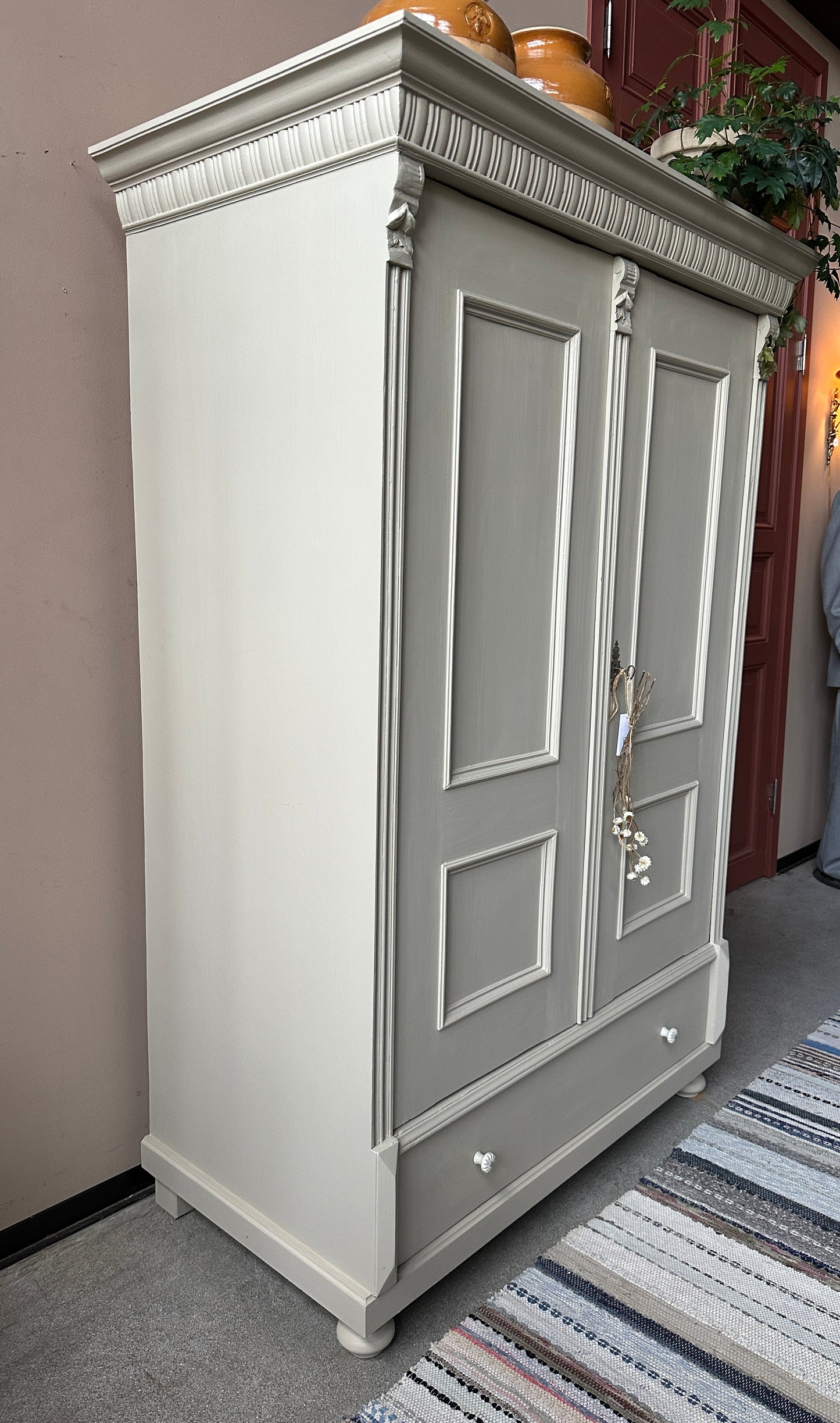 Klassiskt linneskåp i greige kulör med 2 dörrar. bild från sidan