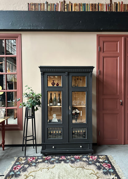 Ett vackert gammalt vitrinskåp med klassiska detaljer och glas även i sidan för vackert ljusinsläpp.