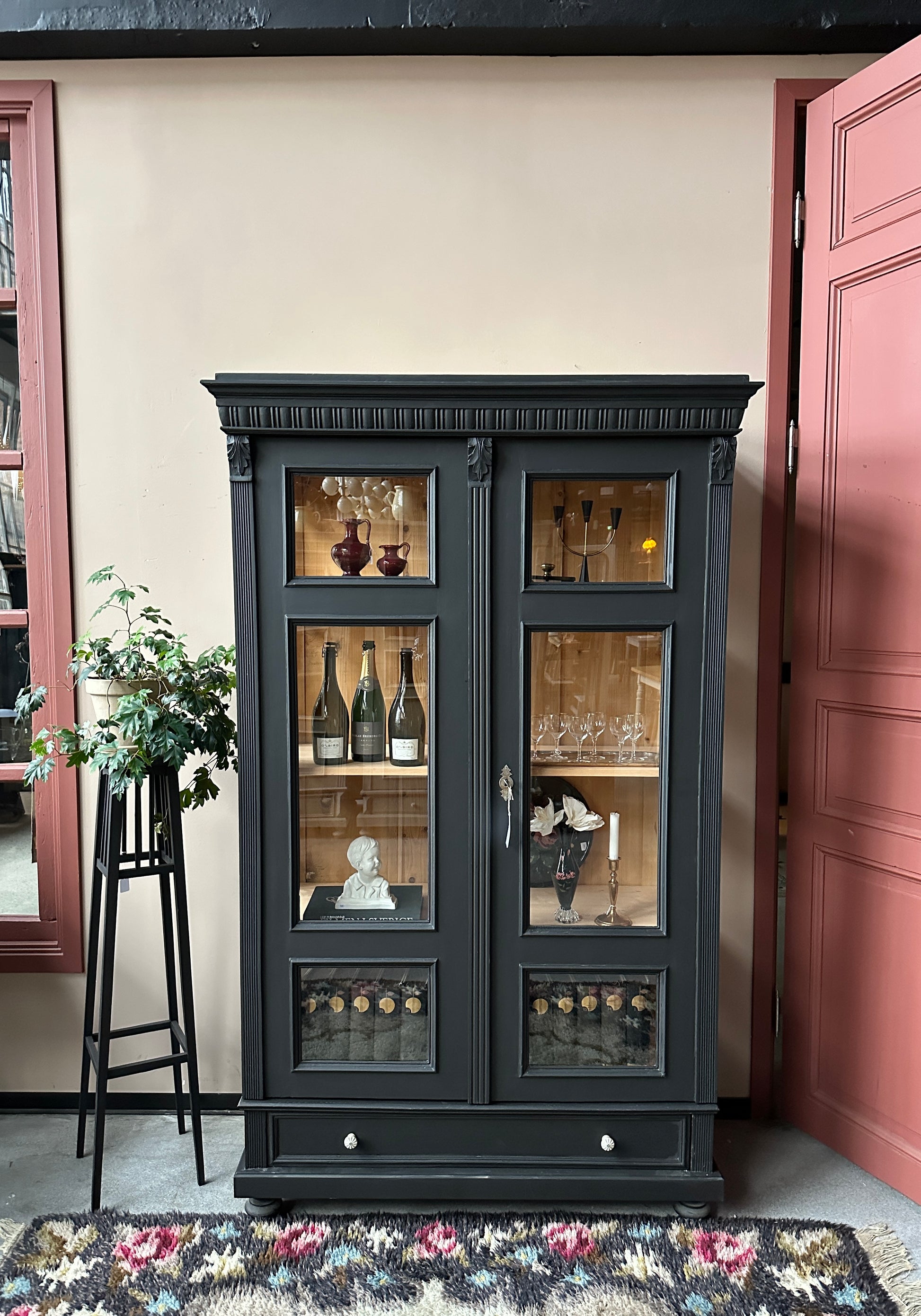 Ett vackert gammalt vitrinskåp med klassiska detaljer och glas även i sidan för vackert ljusinsläpp.