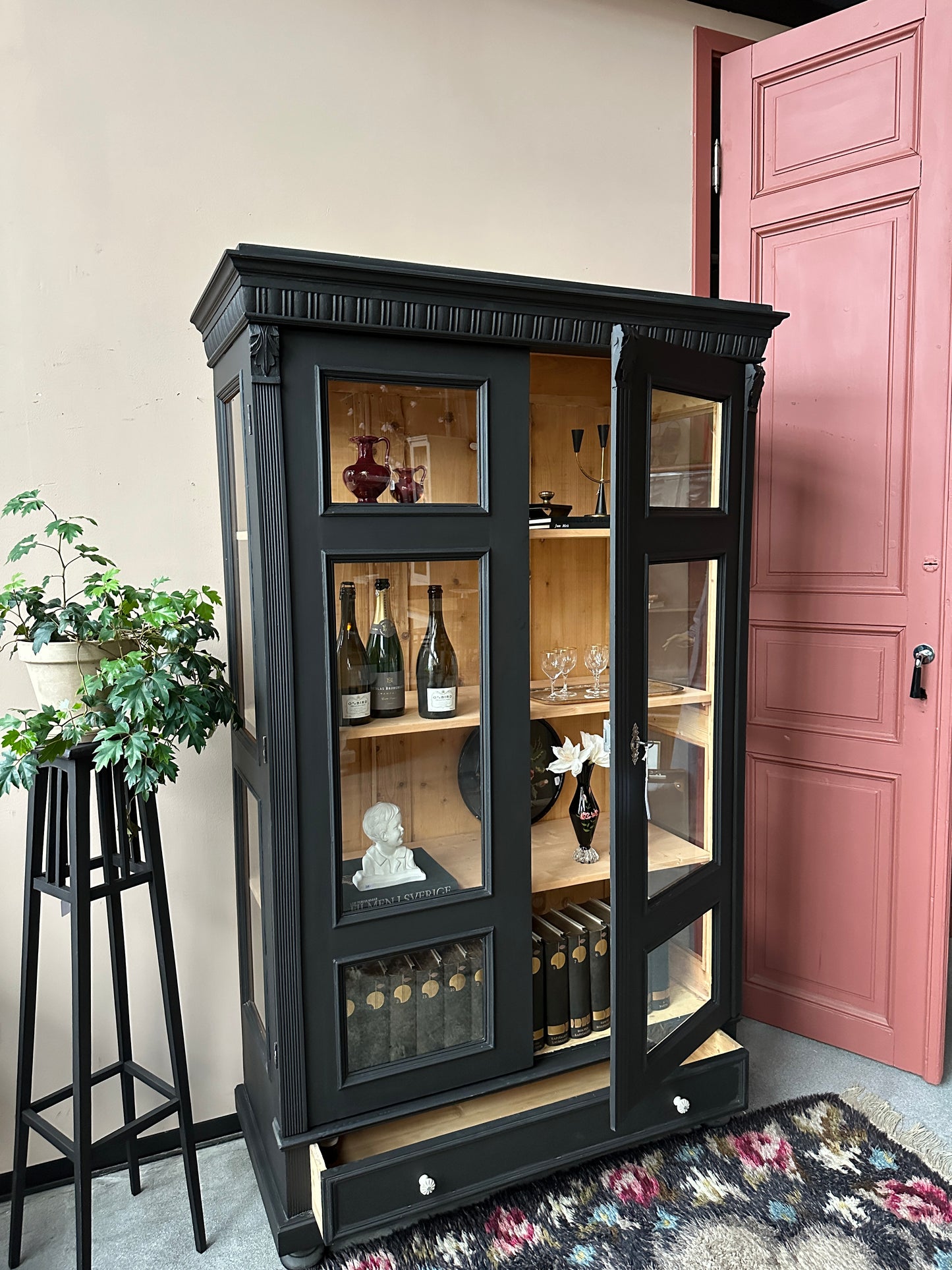 Ett vackert gammalt vitrinskåp med klassiska detaljer och glas även i sidan för vackert ljusinsläpp.