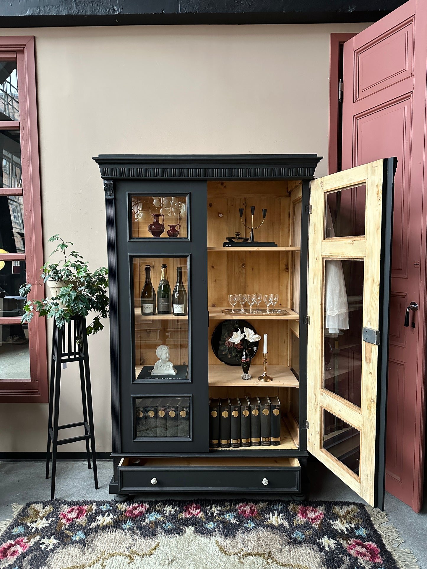 Ett vackert gammalt vitrinskåp med klassiska detaljer och glas även i sidan för vackert ljusinsläpp.