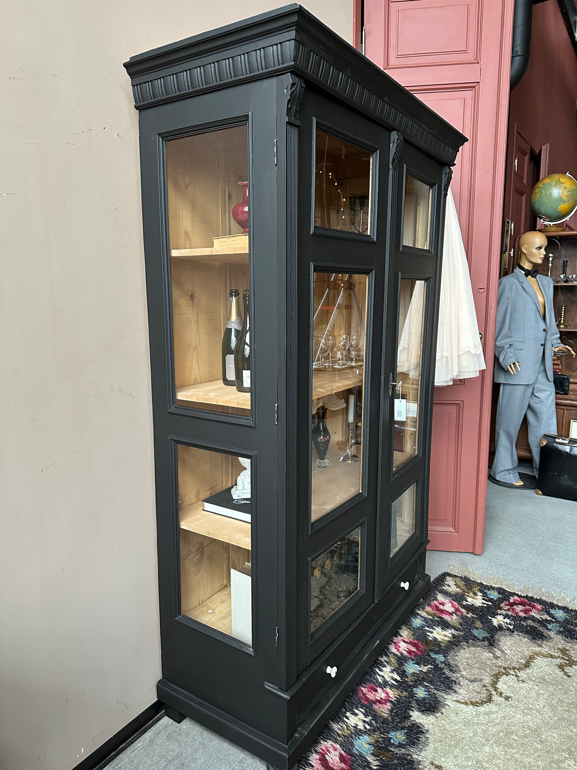 Ett vackert gammalt vitrinskåp med klassiska detaljer och glas även i sidan för vackert ljusinsläpp.