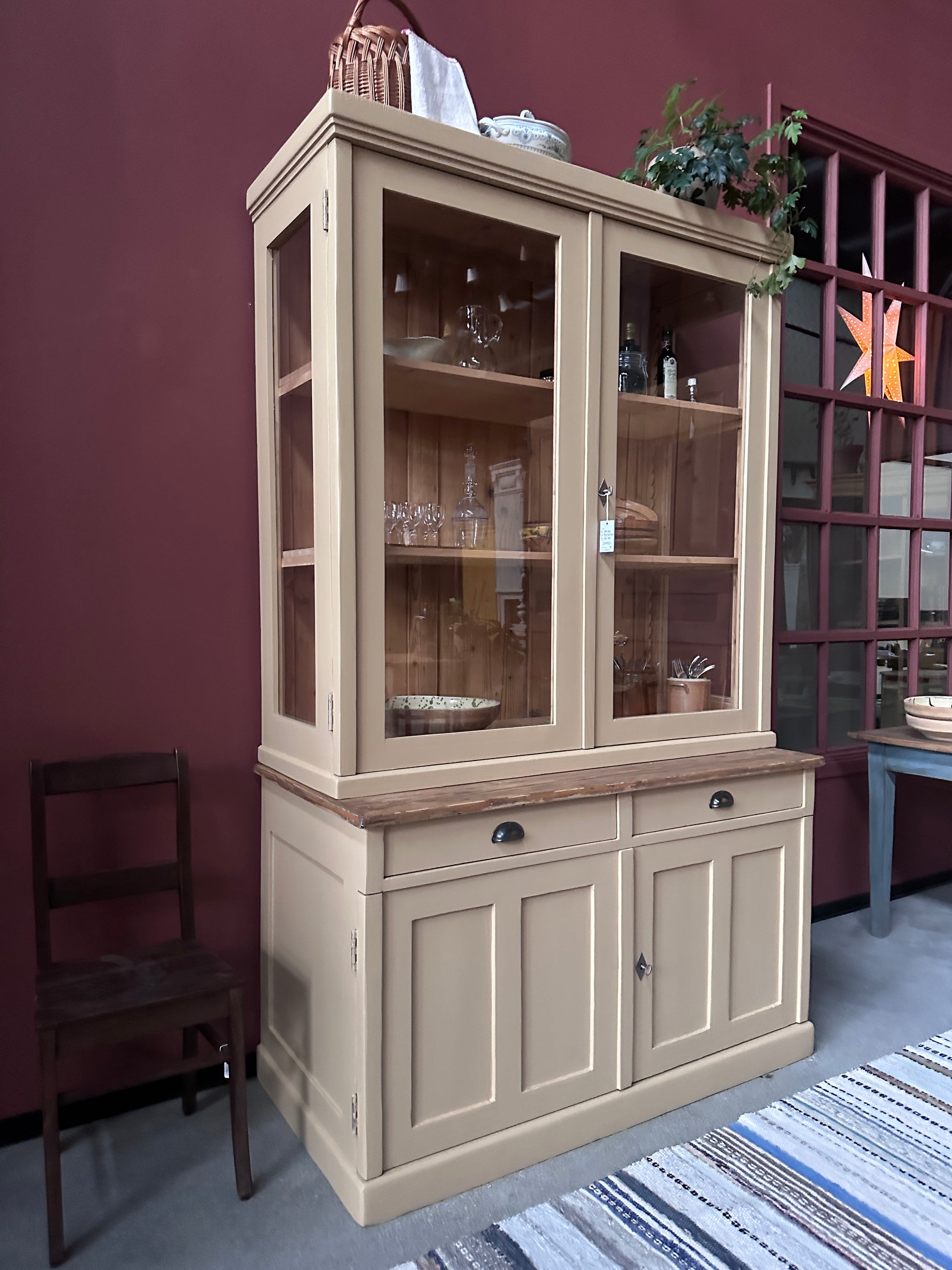 Ett gammalt, vackert köksskåp med härlig utformning och med raka och klassiska detaljer.Skåpet har mängder av praktisk förvaring tack vare såväl vitrindörrar samt skåp som diverse lådor och en svagt pigmenterad bänkskiva i en hårdvaxolja.