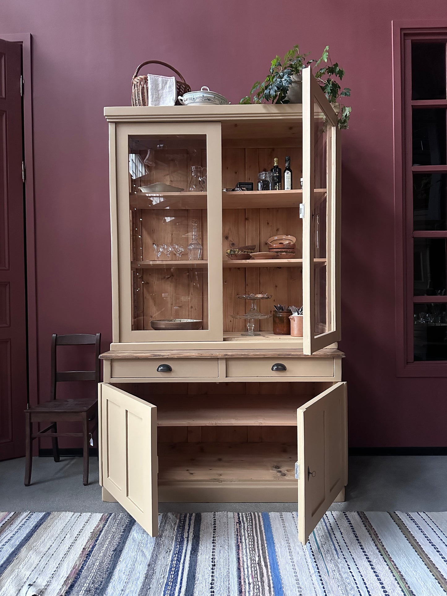 Ett gammalt, vackert köksskåp med härlig utformning och med raka och klassiska detaljer.Skåpet har mängder av praktisk förvaring tack vare såväl vitrindörrar samt skåp som diverse lådor och en svagt pigmenterad bänkskiva i en hårdvaxolja.