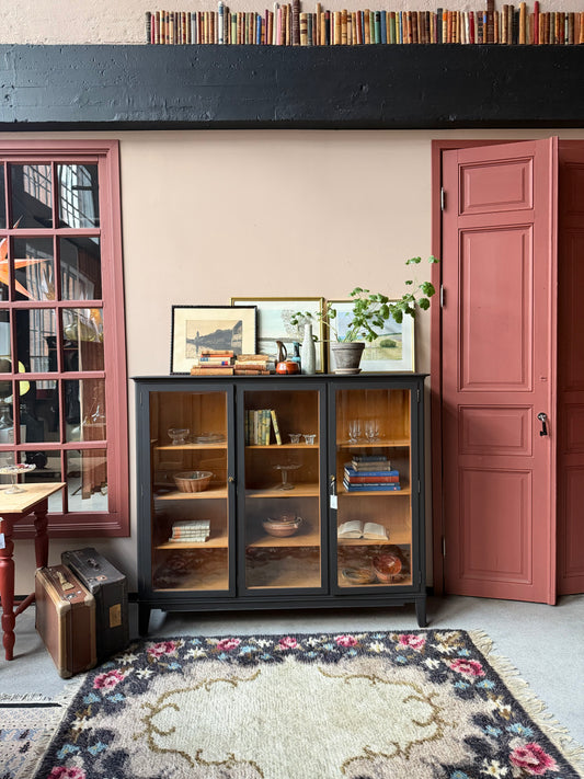 Ett gammalt, vackert vitrinskåp med raköverkant.Skåpet har tre öppningsbara glasdörrar. Praktiskt skåp som rymmer mycket och fint att placera inredningsdetaljer och skapa stilleben utefter säsong på skåpet.