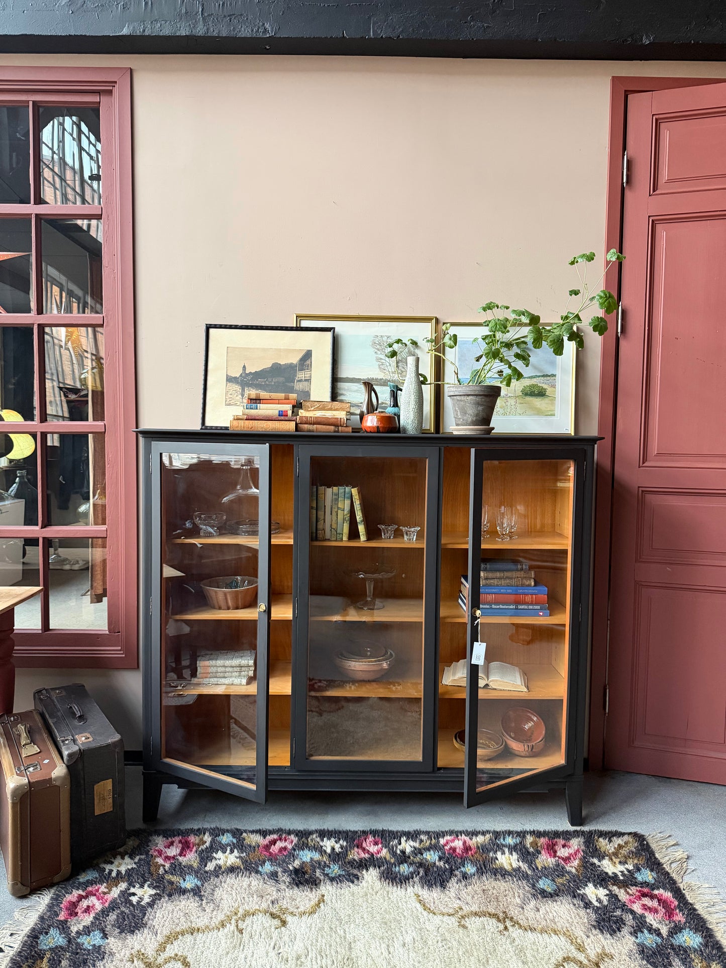 Ett gammalt, vackert vitrinskåp med raköverkant.Skåpet har tre öppningsbara glasdörrar. Praktiskt skåp som rymmer mycket och fint att placera inredningsdetaljer och skapa stilleben utefter säsong på skåpet.