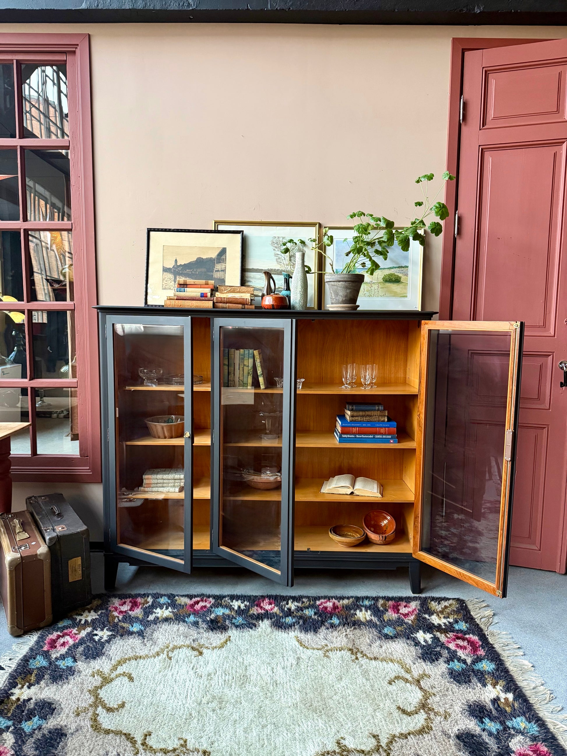 Ett gammalt, vackert vitrinskåp med raköverkant.Skåpet har tre öppningsbara glasdörrar. Praktiskt skåp som rymmer mycket och fint att placera inredningsdetaljer och skapa stilleben utefter säsong på skåpet.