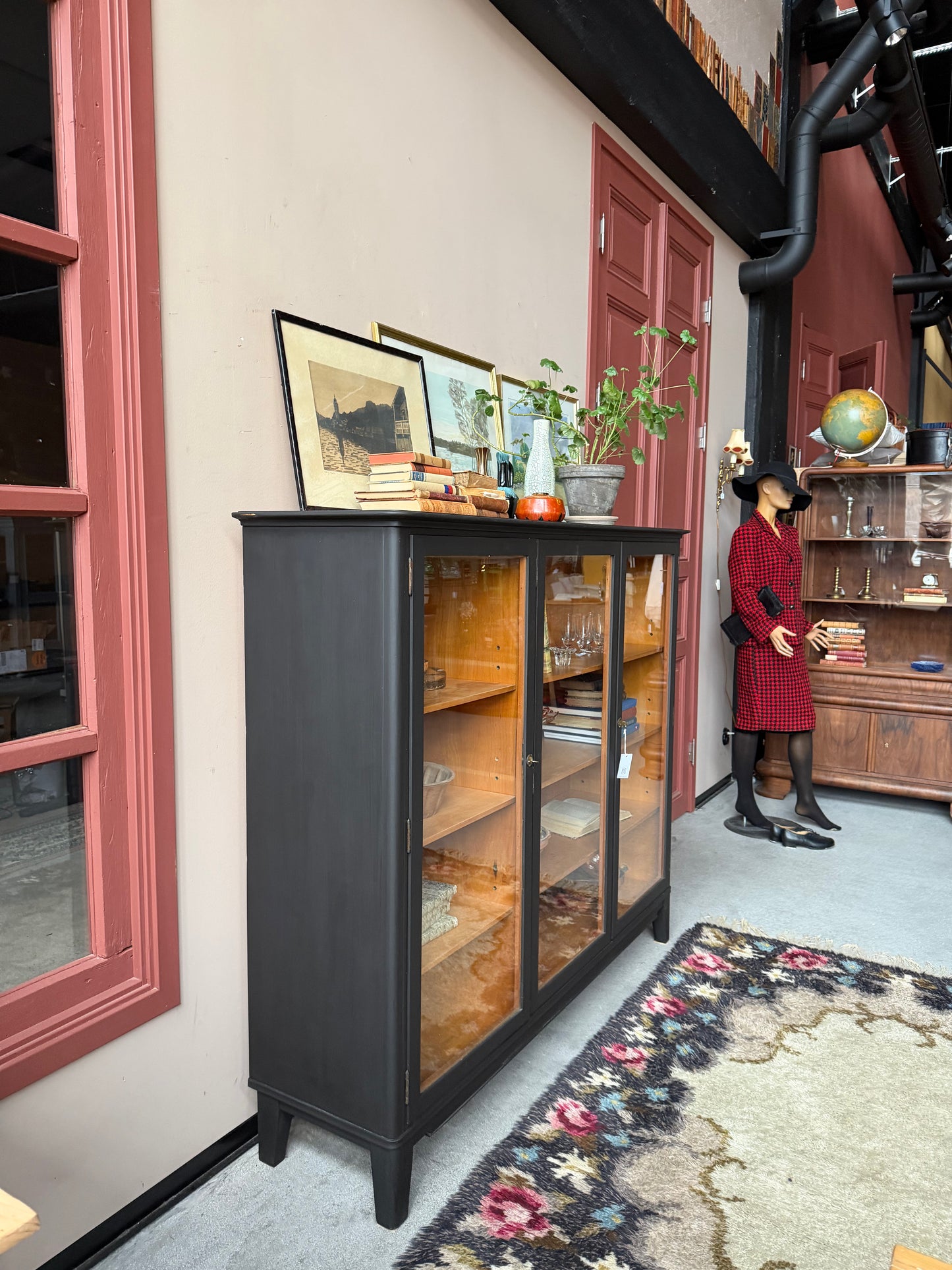 Ett gammalt, vackert vitrinskåp med raköverkant.Skåpet har tre öppningsbara glasdörrar. Praktiskt skåp som rymmer mycket och fint att placera inredningsdetaljer och skapa stilleben utefter säsong på skåpet.