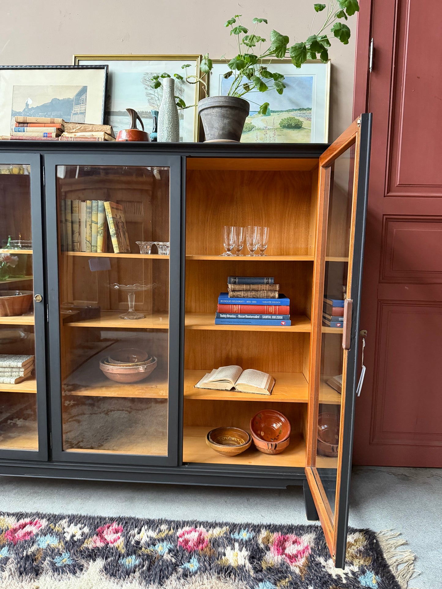 Ett gammalt, vackert vitrinskåp med raköverkant.Skåpet har tre öppningsbara glasdörrar. Praktiskt skåp som rymmer mycket och fint att placera inredningsdetaljer och skapa stilleben utefter säsong på skåpet.