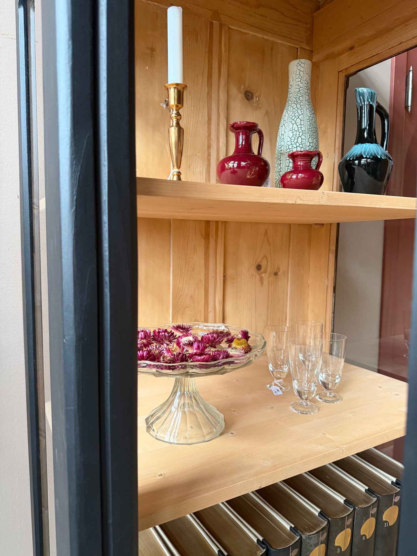 Detaljbild. Ett gammalt vackert vitrinskåp med glas både på framsidan men även på sidorna för fint ljusinsläpp. Formspråket på skåpet är enkelt, men med raka fina detaljer.Det har i dagsläget 3 st hyllplan.Vi kan sätta i ytterligare hyllplan om så önskas.