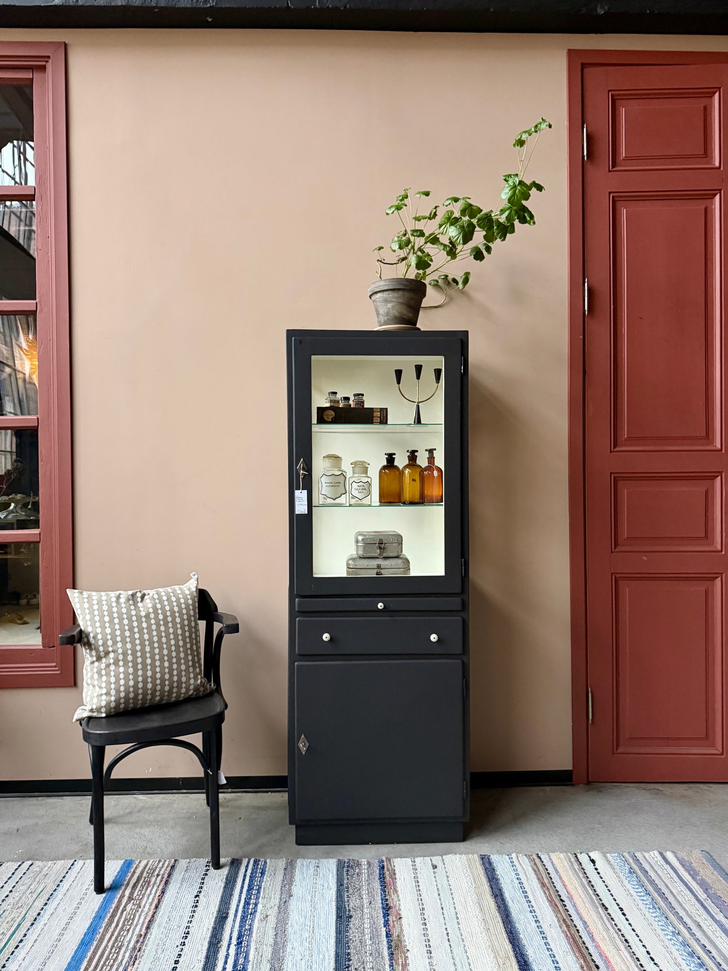 Ett gammalt läckert läkarskåp i trä med två hyllor i glas och även glas i sidan. Ett perfekt skåp för badrummet eller som vitrinskåp i köket .Skåpet har både en utdragbar skiva i trä samt låda och skåp med dold förvaring nertill och med fina porslinsknoppar. Väldigt praktiskt skåp helt enkelt. 