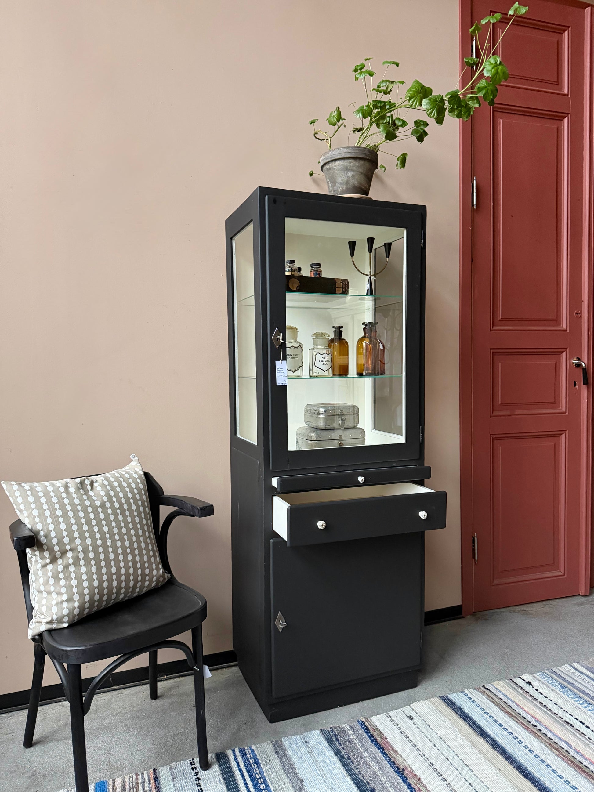 Ett gammalt läckert läkarskåp i trä med två hyllor i glas och även glas i sidan. Ett perfekt skåp för badrummet eller som vitrinskåp i köket .Skåpet har både en utdragbar skiva i trä samt låda och skåp med dold förvaring nertill och med fina porslinsknoppar. Väldigt praktiskt skåp helt enkelt. 