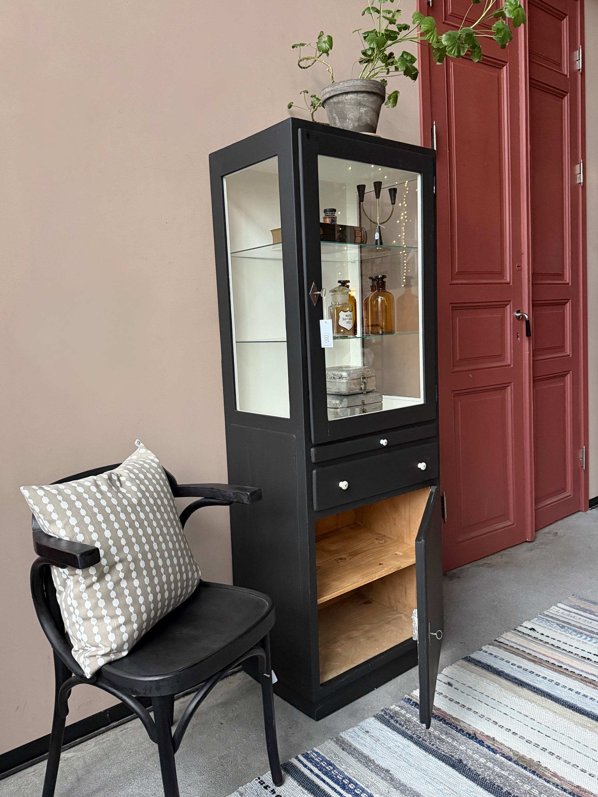 Ett gammalt läckert läkarskåp i trä med två hyllor i glas och även glas i sidan. Ett perfekt skåp för badrummet eller som vitrinskåp i köket .Skåpet har både en utdragbar skiva i trä samt låda och skåp med dold förvaring nertill och med fina porslinsknoppar. Väldigt praktiskt skåp helt enkelt. 