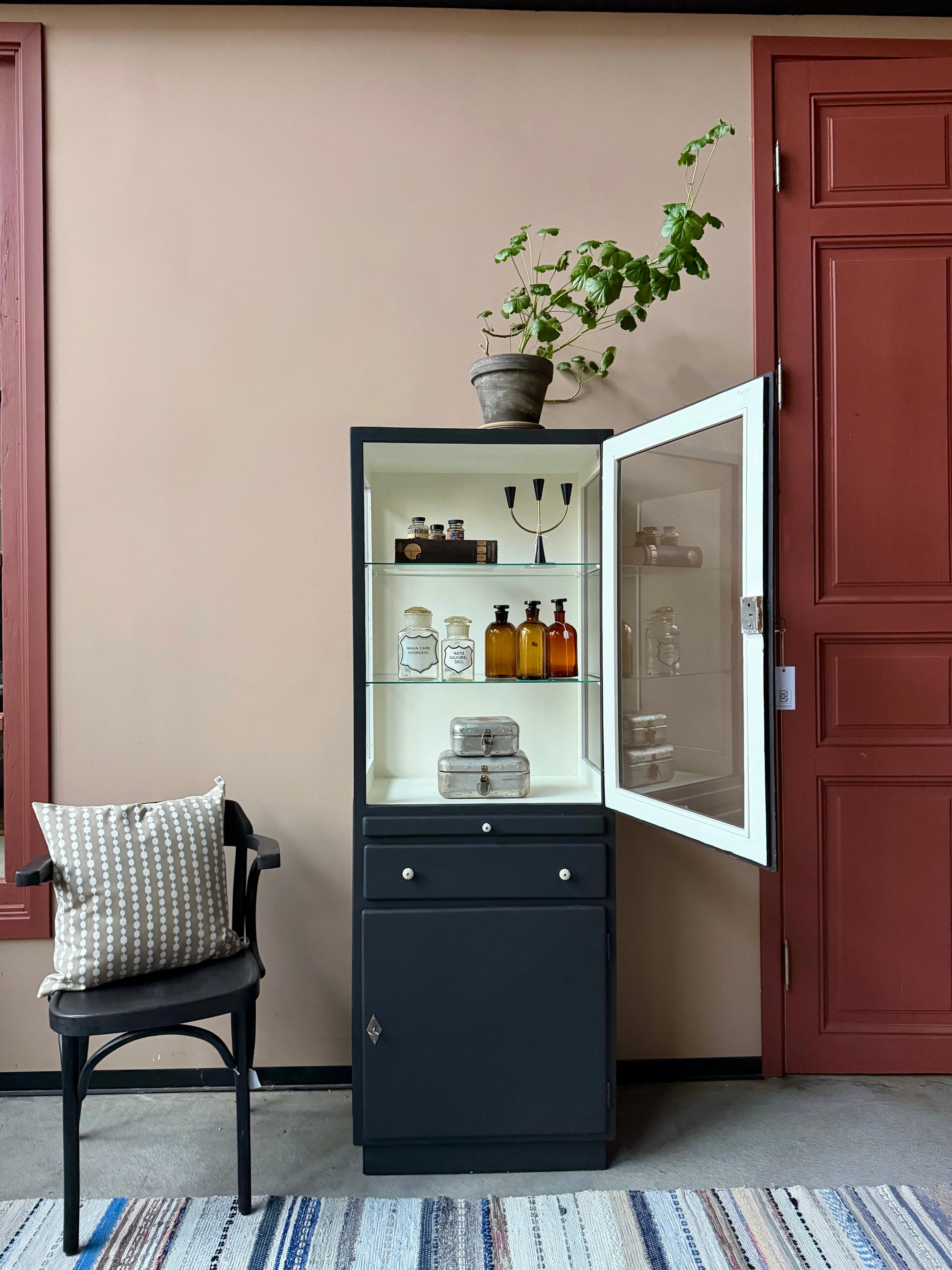 Ett gammalt läckert läkarskåp i trä med två hyllor i glas och även glas i sidan. Ett perfekt skåp för badrummet eller som vitrinskåp i köket .Skåpet har både en utdragbar skiva i trä samt låda och skåp med dold förvaring nertill och med fina porslinsknoppar. Väldigt praktiskt skåp helt enkelt. 