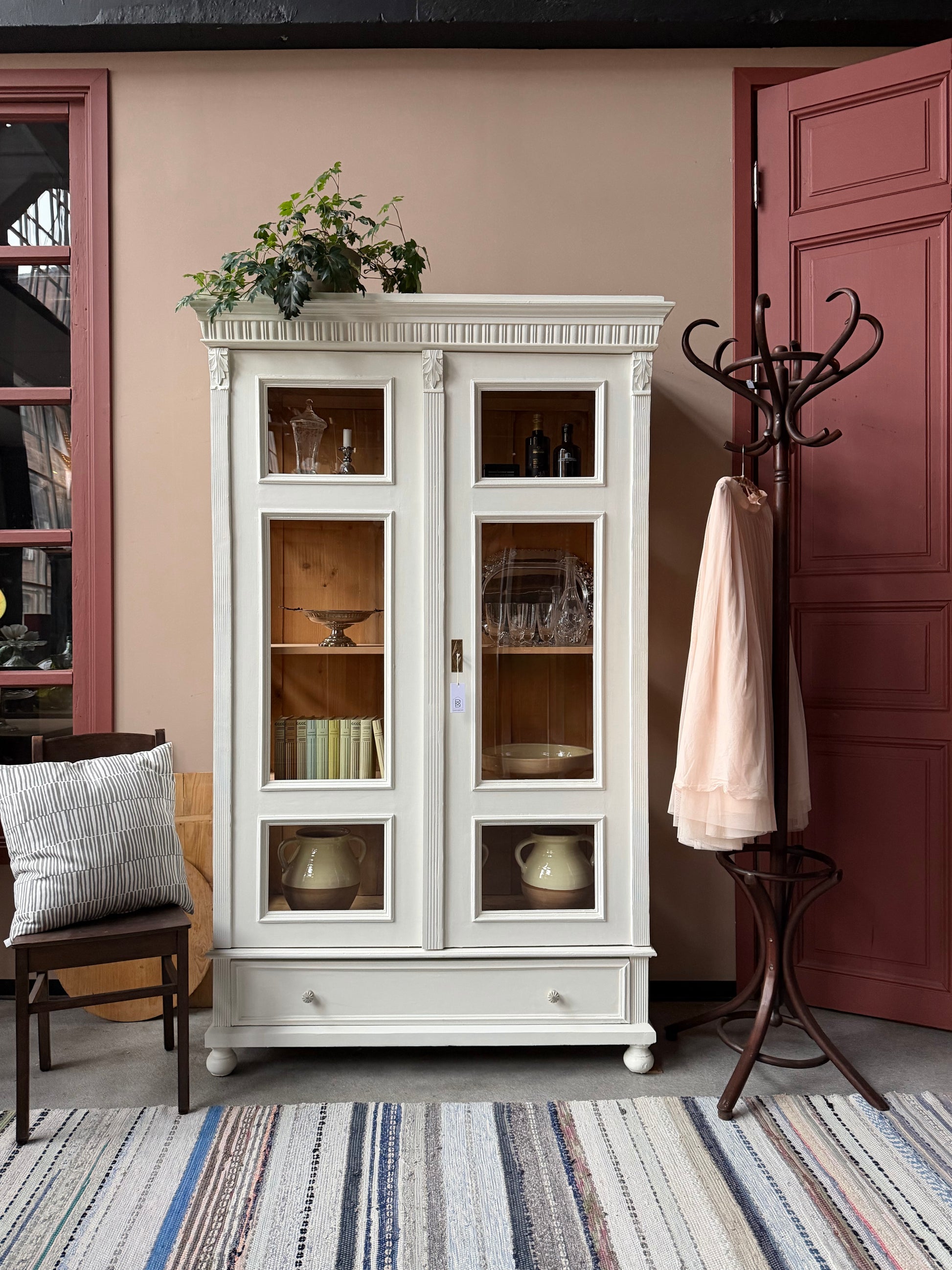 Ett gammalt vackert vitrinskåp med många fina och klassiska detaljer. Skåpet har vitringlas även i sidorna för vackert ljusinsläpp. Skåpet har i dagsläget 3 st nya och fräscha hyllplan. Skåpet har en stor och praktisk låda nertill med porslinsknoppar.