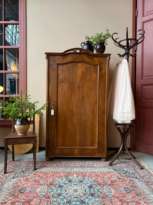 Ett gammalt vackert linneskåp i trä med en dörr och runda former. Utvändigt är skåpet vaxat i en mörkbrun nyans för fin lyster. 