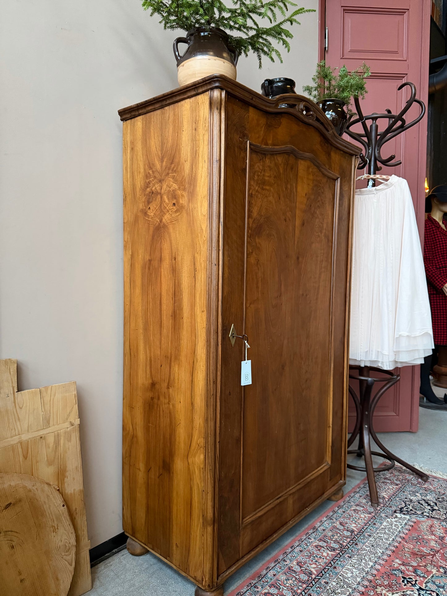 Ett gammalt vackert linneskåp i trä med en dörr och runda former. Utvändigt är skåpet vaxat i en mörkbrun nyans för fin lyster. 