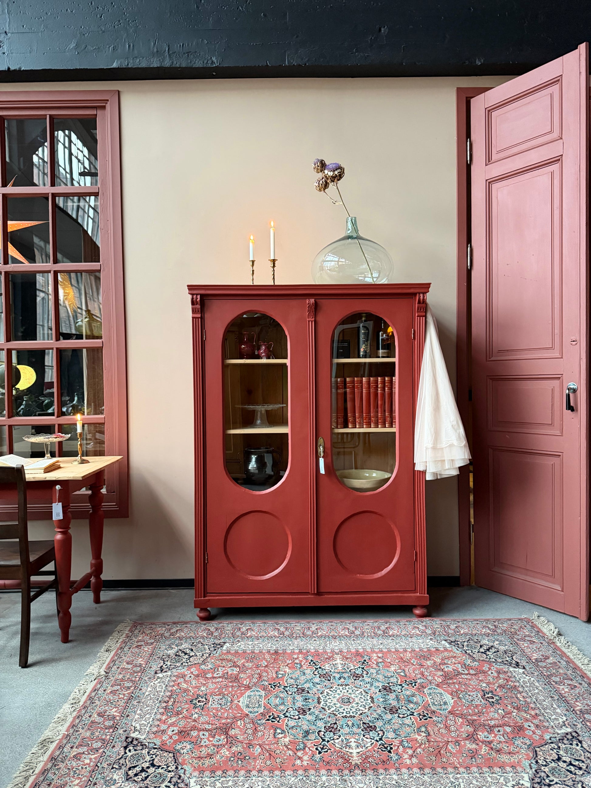 Ett gammalt vackert vitrinskåp med många fina och klassiska detaljer. Skåpet har rundade vitringlas i dörrarna vilket är en fantastiskt fin och unik utsmyckning. 