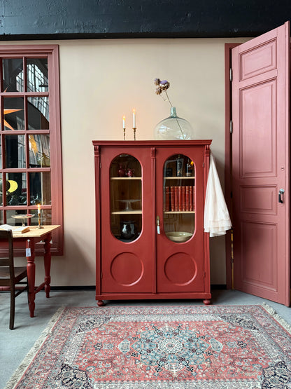 Ett gammalt vackert vitrinskåp med många fina och klassiska detaljer. Skåpet har rundade vitringlas i dörrarna vilket är en fantastiskt fin och unik utsmyckning. 