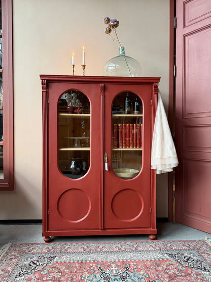 Ett gammalt vackert vitrinskåp med många fina och klassiska detaljer. Skåpet har rundade vitringlas i dörrarna vilket är en fantastiskt fin och unik utsmyckning. 