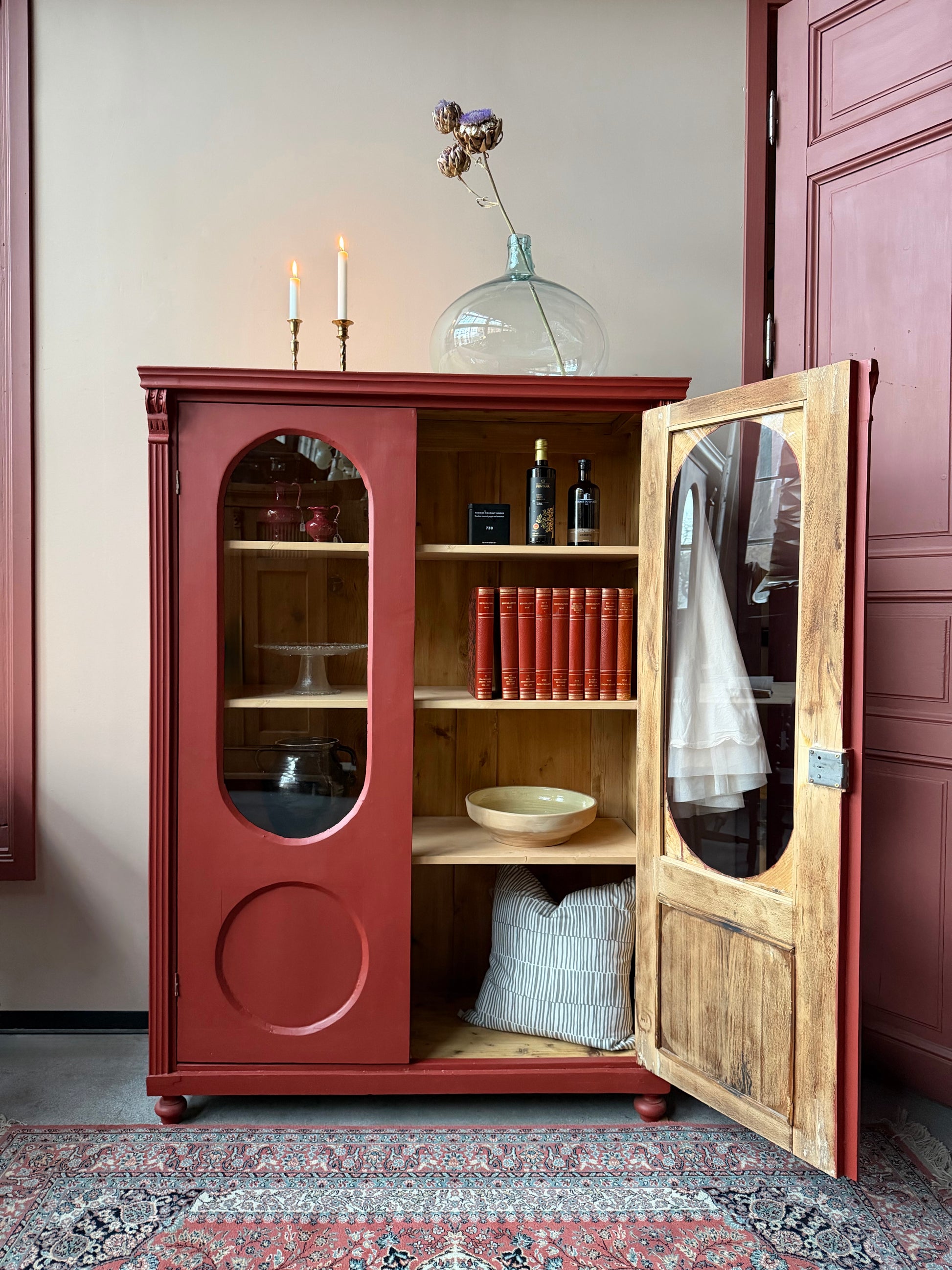 Ett gammalt vackert vitrinskåp med många fina och klassiska detaljer. Skåpet har rundade vitringlas i dörrarna vilket är en fantastiskt fin och unik utsmyckning. 