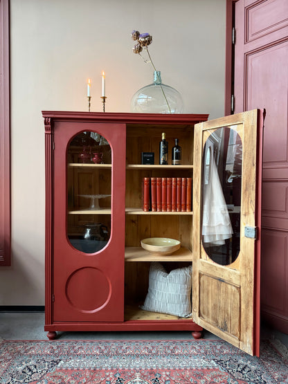 Ett gammalt vackert vitrinskåp med många fina och klassiska detaljer. Skåpet har rundade vitringlas i dörrarna vilket är en fantastiskt fin och unik utsmyckning. 