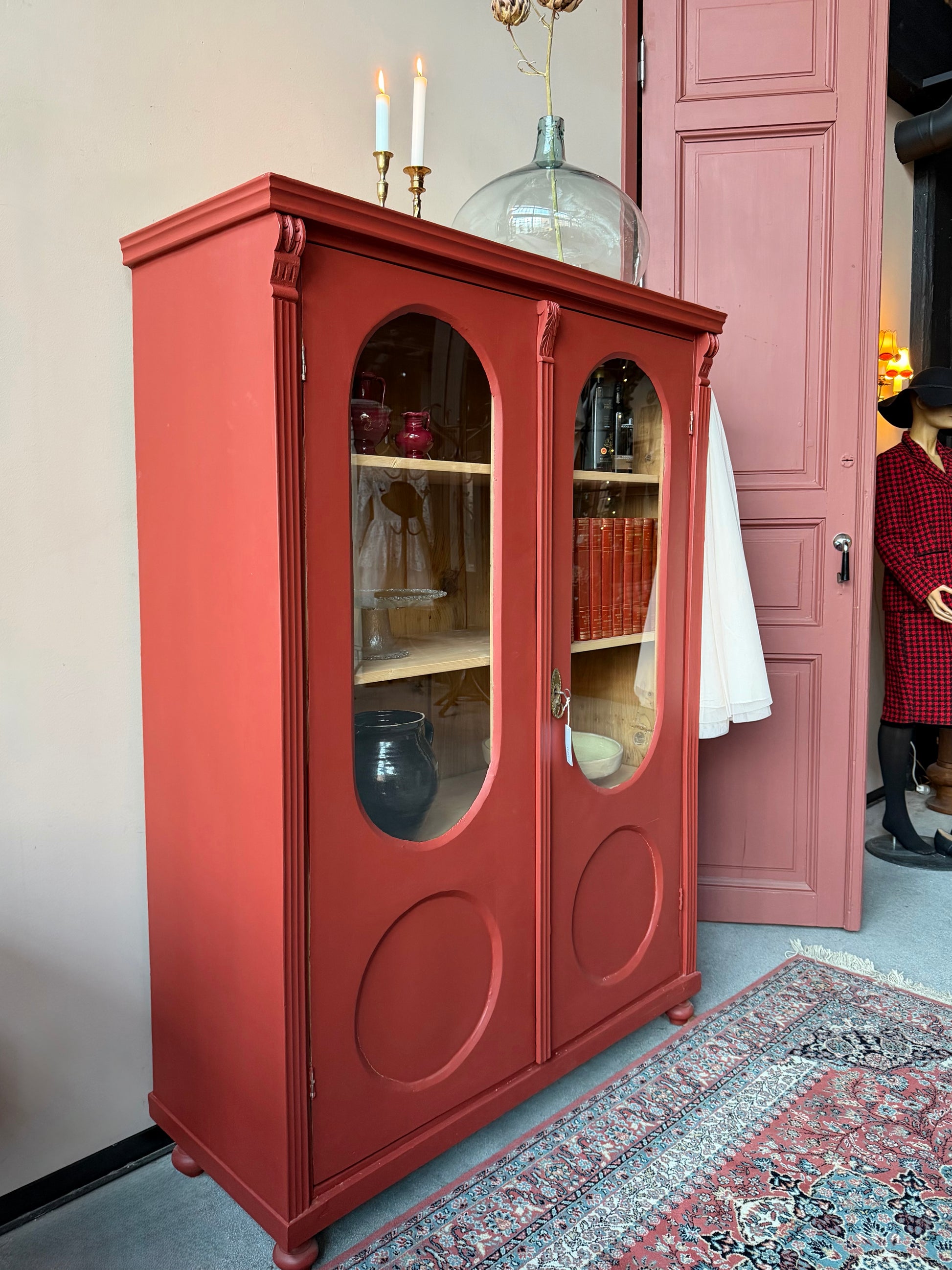 Ett gammalt vackert vitrinskåp med många fina och klassiska detaljer. Skåpet har rundade vitringlas i dörrarna vilket är en fantastiskt fin och unik utsmyckning. 