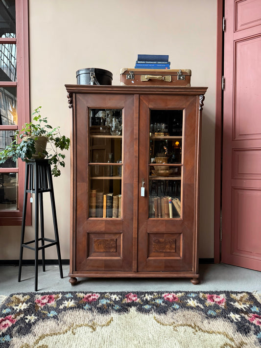 Ett gammalt vackert vitrinskåp med fina detaljer och utsmyckning i dess raka och enkla linjer.