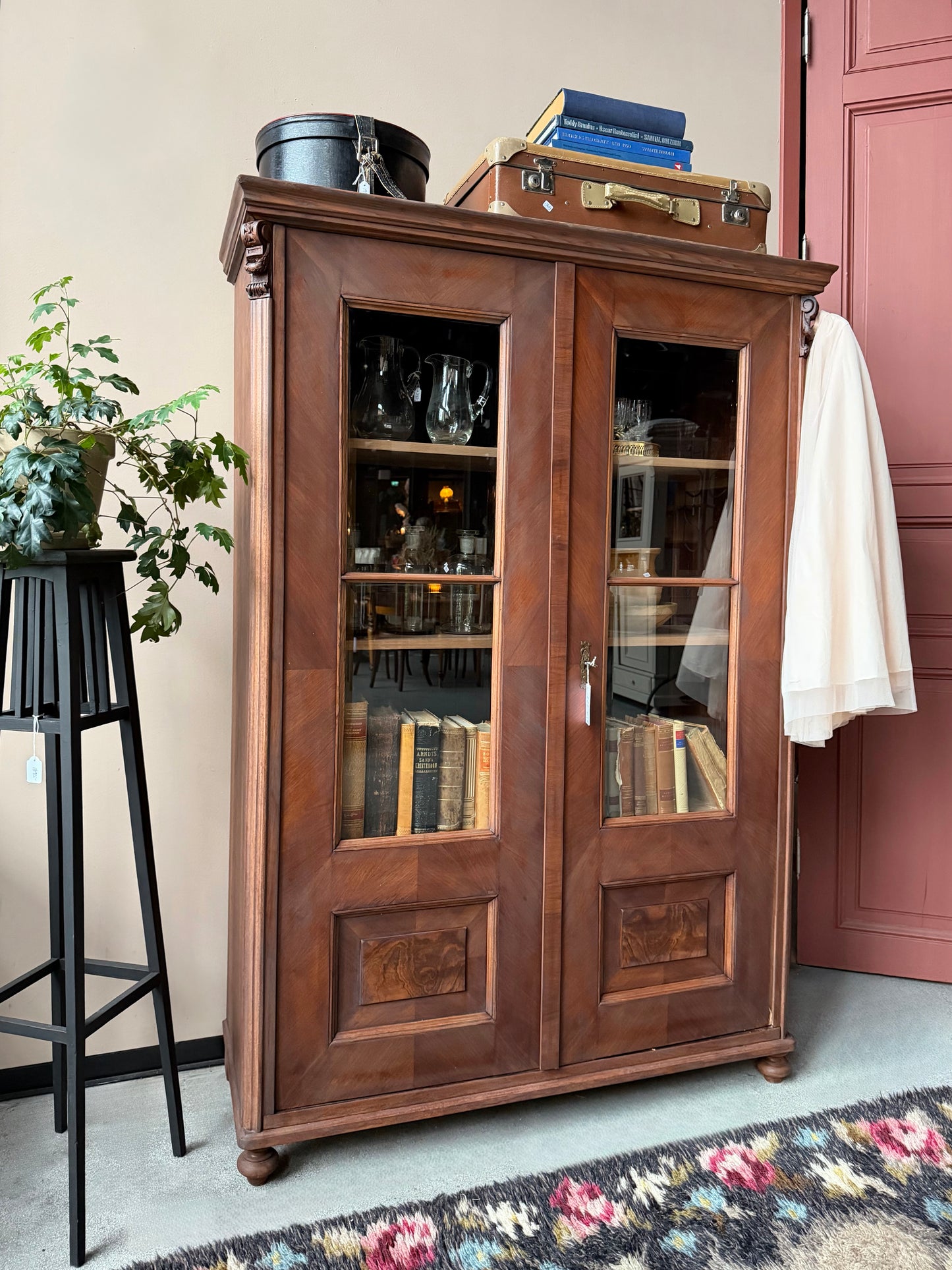 Ett gammalt vackert vitrinskåp med fina detaljer och utsmyckning i dess raka och enkla linjer.