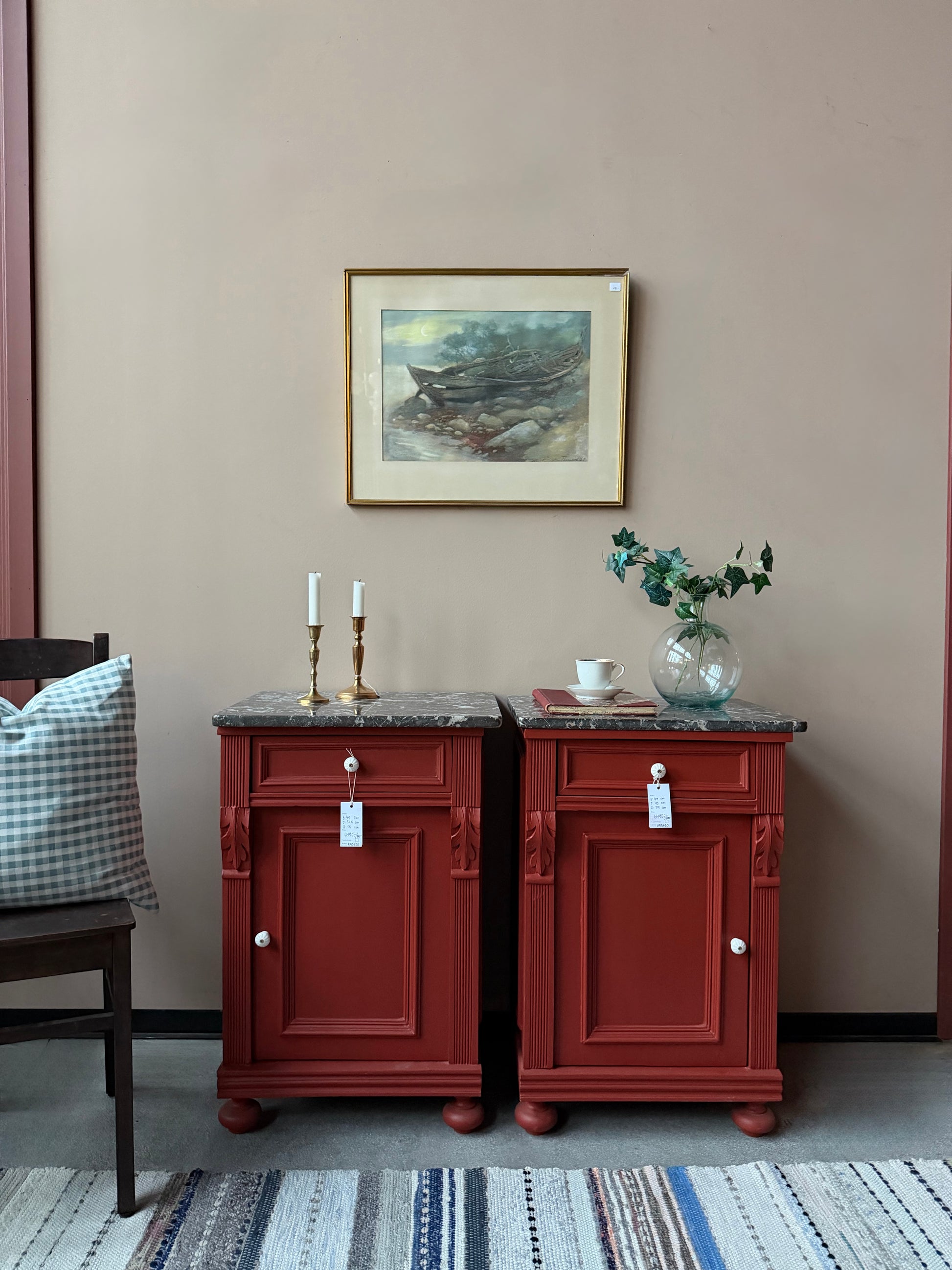 Ett par gamla, vackra sängbord med fin utsmyckning och klassisk form med både låda och skåp. Sängborden har en fantastiskt vacker svart/vit marmorerad toppskiva i sten som är avtagbar. Sängborden är varsamt renoverade och slutligen penselmålade med en matt snickerifärg i Dakaboms varmröda kulör.