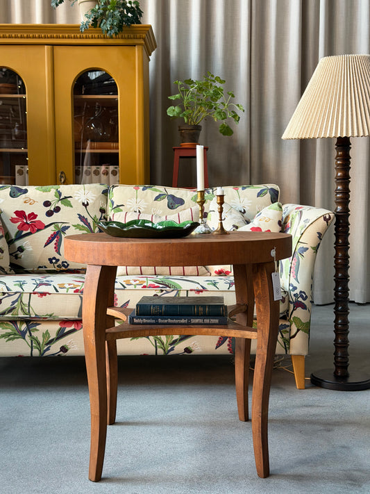 Ett gammalt vackert nätt bord med runda former och ytterligare avställningsyta på en underhylla.