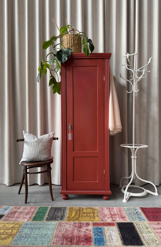 Ett gammalt vackert varmrött linneskåp med enkla och raka former.