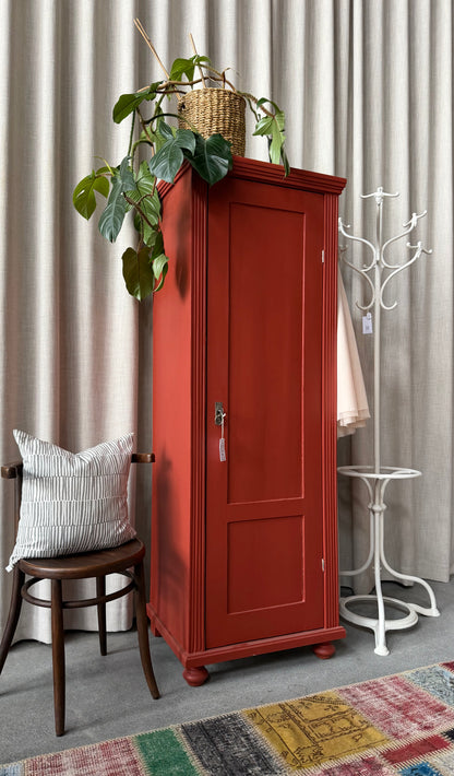 Ett gammalt vackert varmrött linneskåp med enkla och raka former.