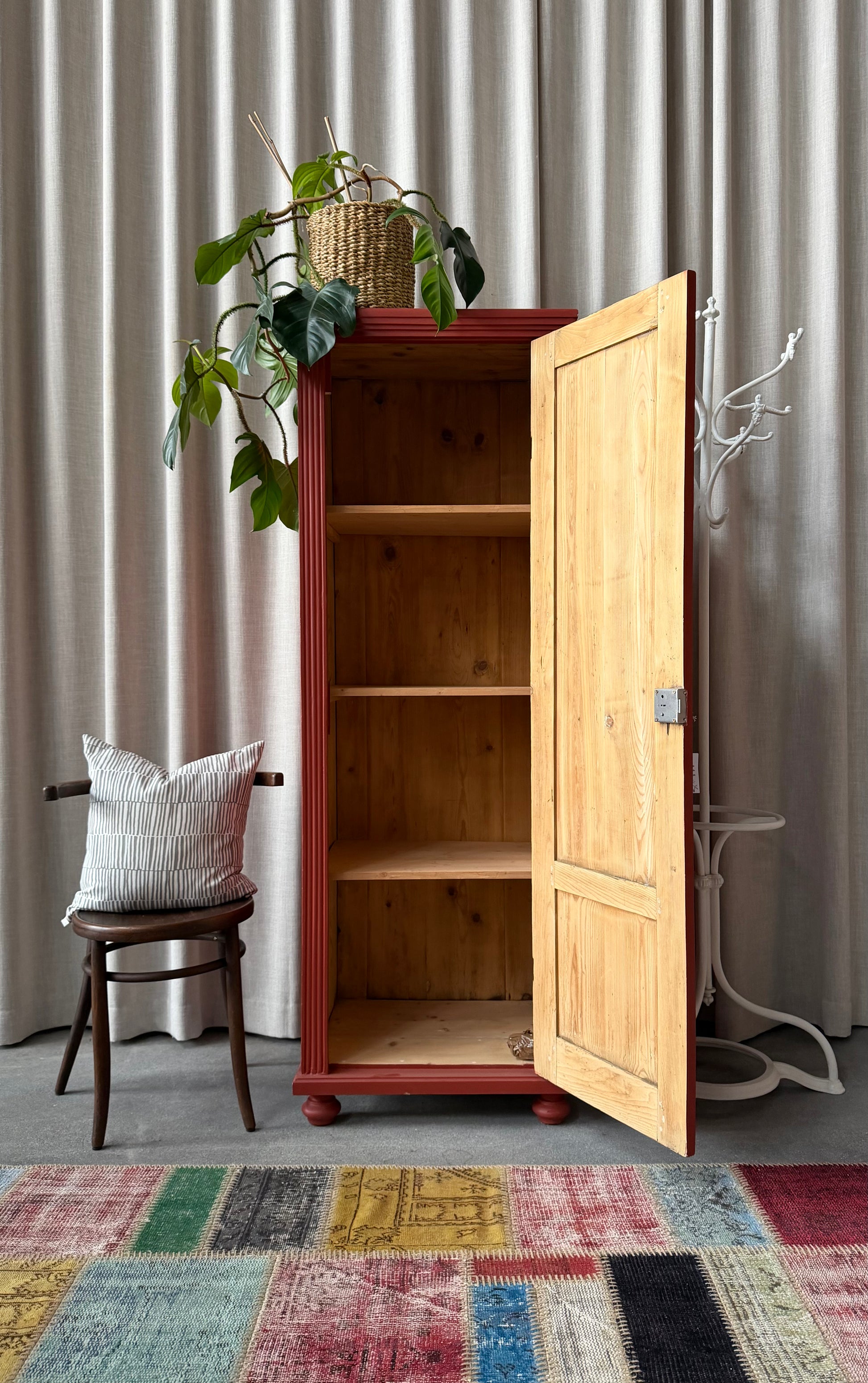 Ett gammalt vackert varmrött linneskåp med enkla och raka former.