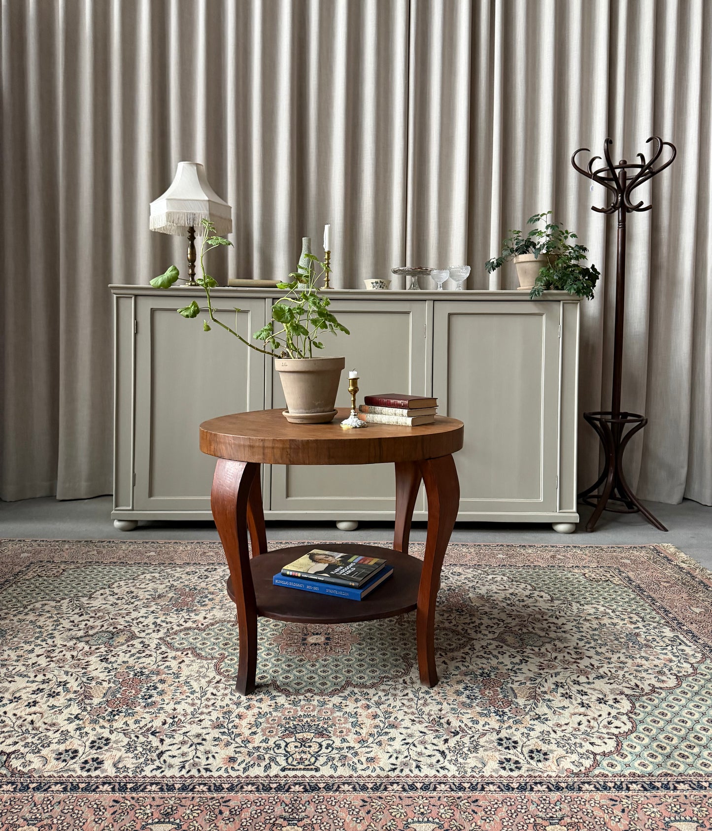 Ett gammalt vackert nätt bord med runda former och ytterligare avställningsyta på en underhylla.