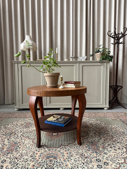 Ett gammalt vackert nätt bord med runda former och ytterligare avställningsyta på en underhylla.