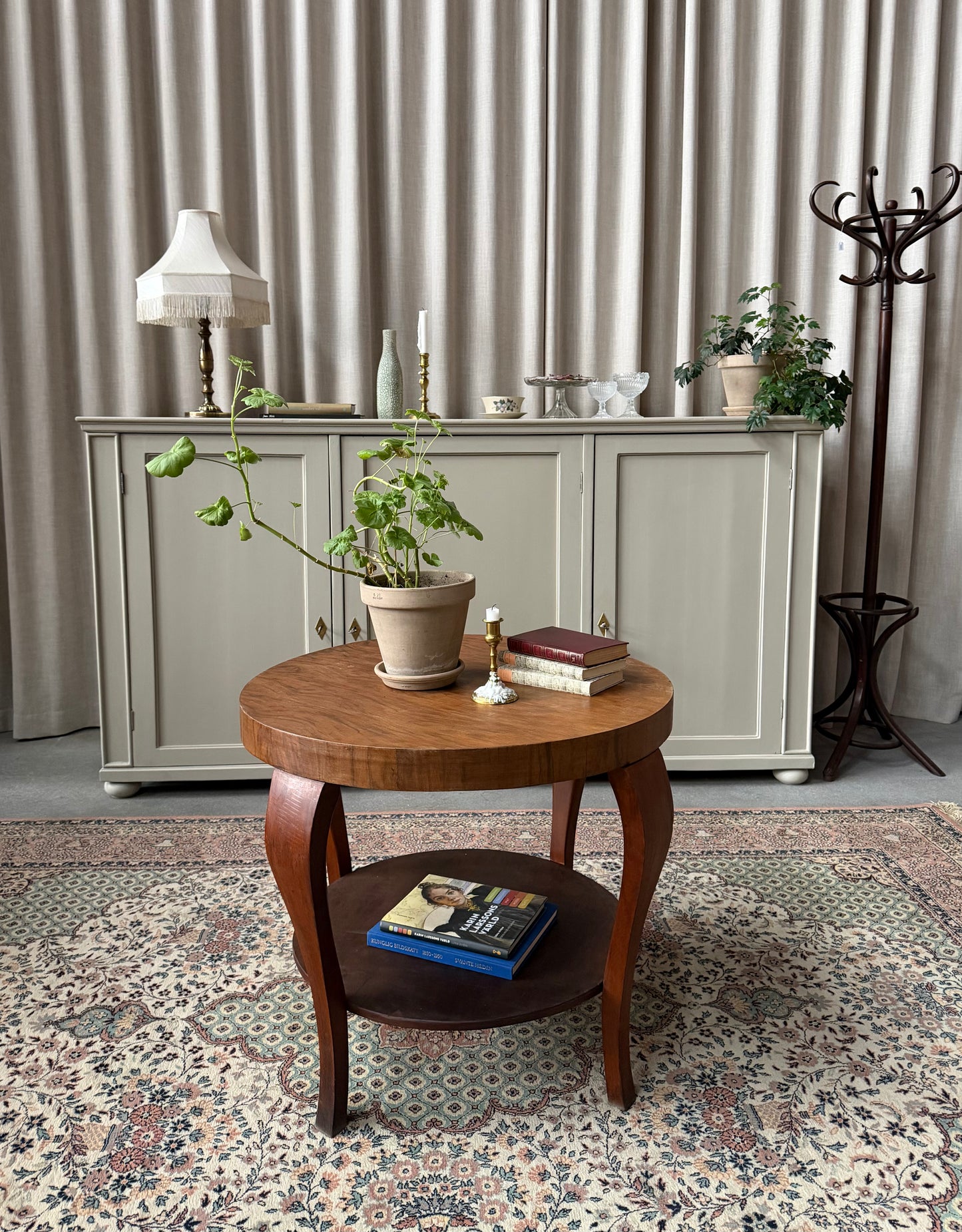 Ett gammalt vackert nätt bord med runda former och ytterligare avställningsyta på en underhylla.