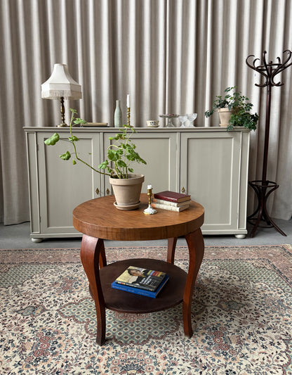 Ett gammalt vackert nätt bord med runda former och ytterligare avställningsyta på en underhylla.