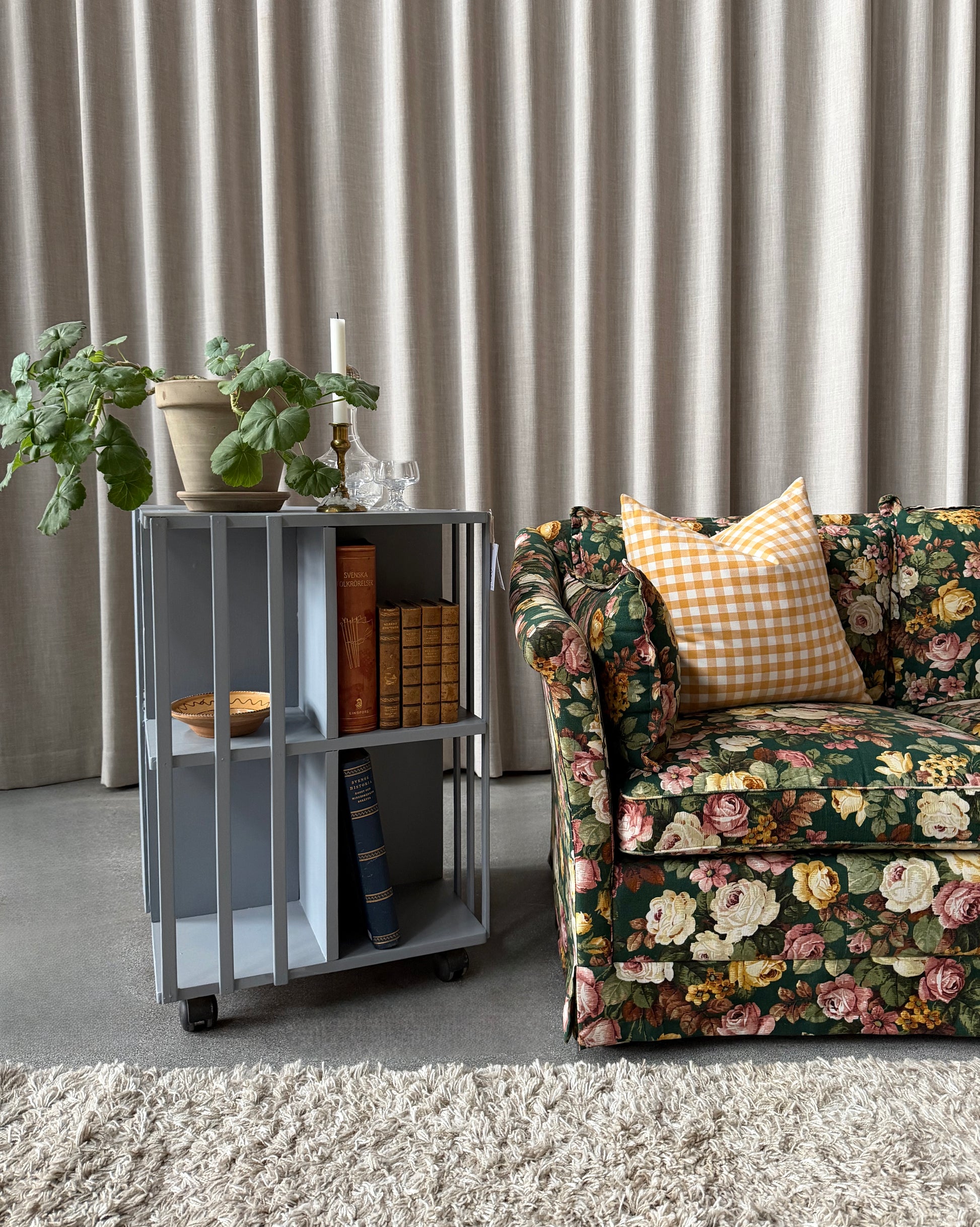 Ett vackert kvadratiskt sidebord/litet bord på hjul med ljuvliga små hyllor/fack på alla sidor vilket gör att det passar fint i rummet som sidebord att fylla med böcker och andra stilleben. Det är varsamt renoverat och målat i en ljust blå/grå kulör. 