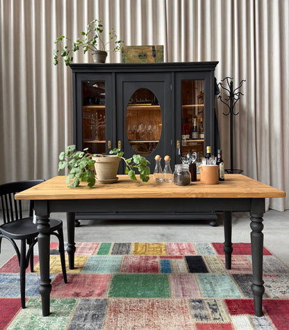 Ett vackert bord med en återbrukad toppskiva och ett nytillverkat underrede i furu.
Ben och sarg är penselmålade med en matt kalkfärg i en svart kulör. 