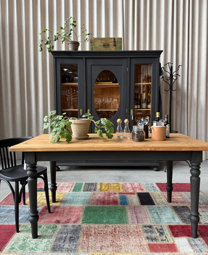 Ett vackert bord med en återbrukad toppskiva och ett nytillverkat underrede i furu.
Ben och sarg är penselmålade med en matt kalkfärg i en svart kulör. 