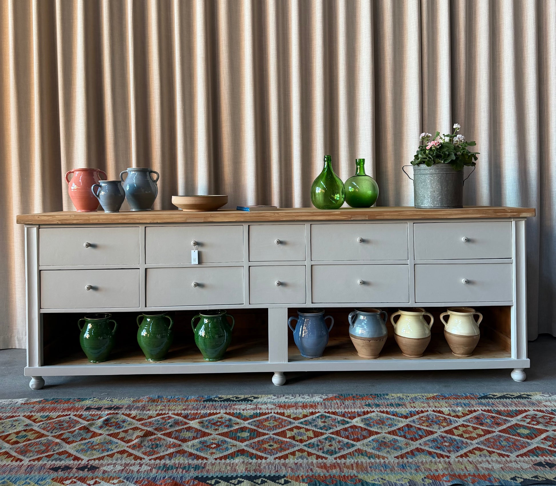 En vacker köksö/sidebord/bänk med 10 lådor med nya vackra porslinsknoppar i äldre stil och en underhylla för praktisk förvaring. Eftersom köksön är fin även på "baksidan" så passar den bra mitt i rummet, praktiskt och snyggt. Den passar även perfekt in i en butik, antingen som kassadisk eller sidebord fylld med inredning eller krukor och blommor. 