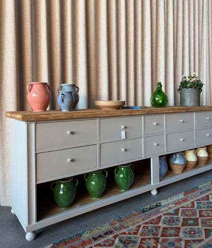 En vacker köksö/sidebord/bänk med 10 lådor med nya vackra porslinsknoppar i äldre stil och en underhylla för praktisk förvaring. Eftersom köksön är fin även på "baksidan" så passar den bra mitt i rummet, praktiskt och snyggt. Den passar även perfekt in i en butik, antingen som kassadisk eller sidebord fylld med inredning eller krukor och blommor. 