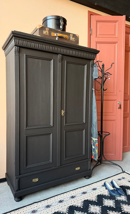 Ett gammalt vackert linneskåp med utsmyckade detaljer och profilerade speglar.