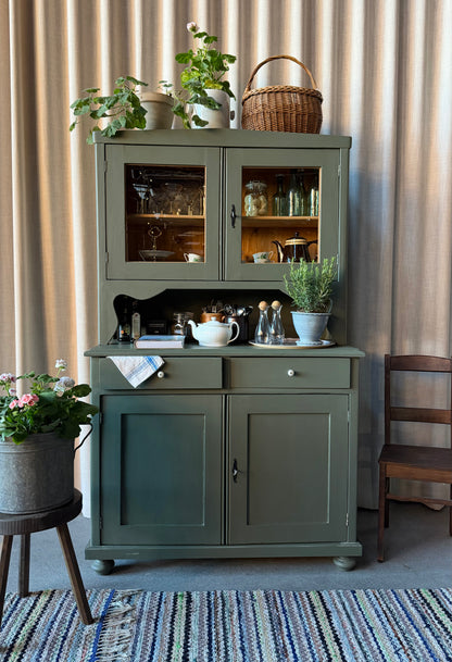 Ett gammalt, vackert och charmigt köksskåp med härlig utformning.Förutom vitrin, täckta skåp och öppen avställningsyta så har detta köksskåp även 2 st lådor med nya fina porslinsknoppar i äldre stil. 