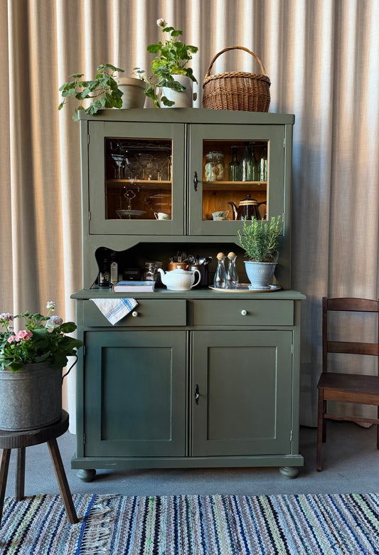 Ett gammalt, vackert och charmigt köksskåp med härlig utformning.Förutom vitrin, täckta skåp och öppen avställningsyta så har detta köksskåp även 2 st lådor med nya fina porslinsknoppar i äldre stil. 