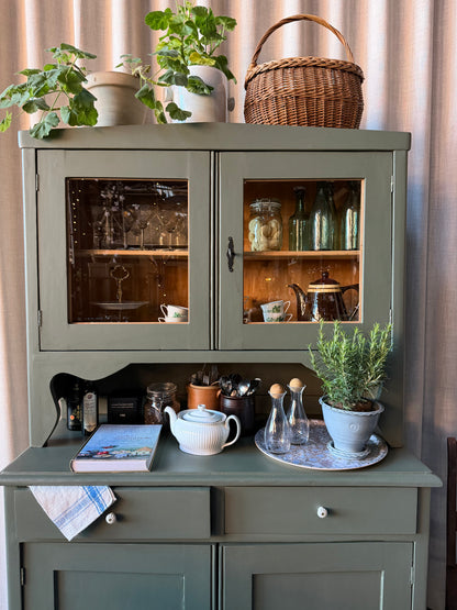 Ett gammalt, vackert och charmigt köksskåp med härlig utformning.Förutom vitrin, täckta skåp och öppen avställningsyta så har detta köksskåp även 2 st lådor med nya fina porslinsknoppar i äldre stil. 