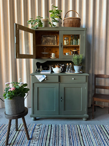 Ett gammalt, vackert och charmigt köksskåp med härlig utformning.Förutom vitrin, täckta skåp och öppen avställningsyta så har detta köksskåp även 2 st lådor med nya fina porslinsknoppar i äldre stil. 