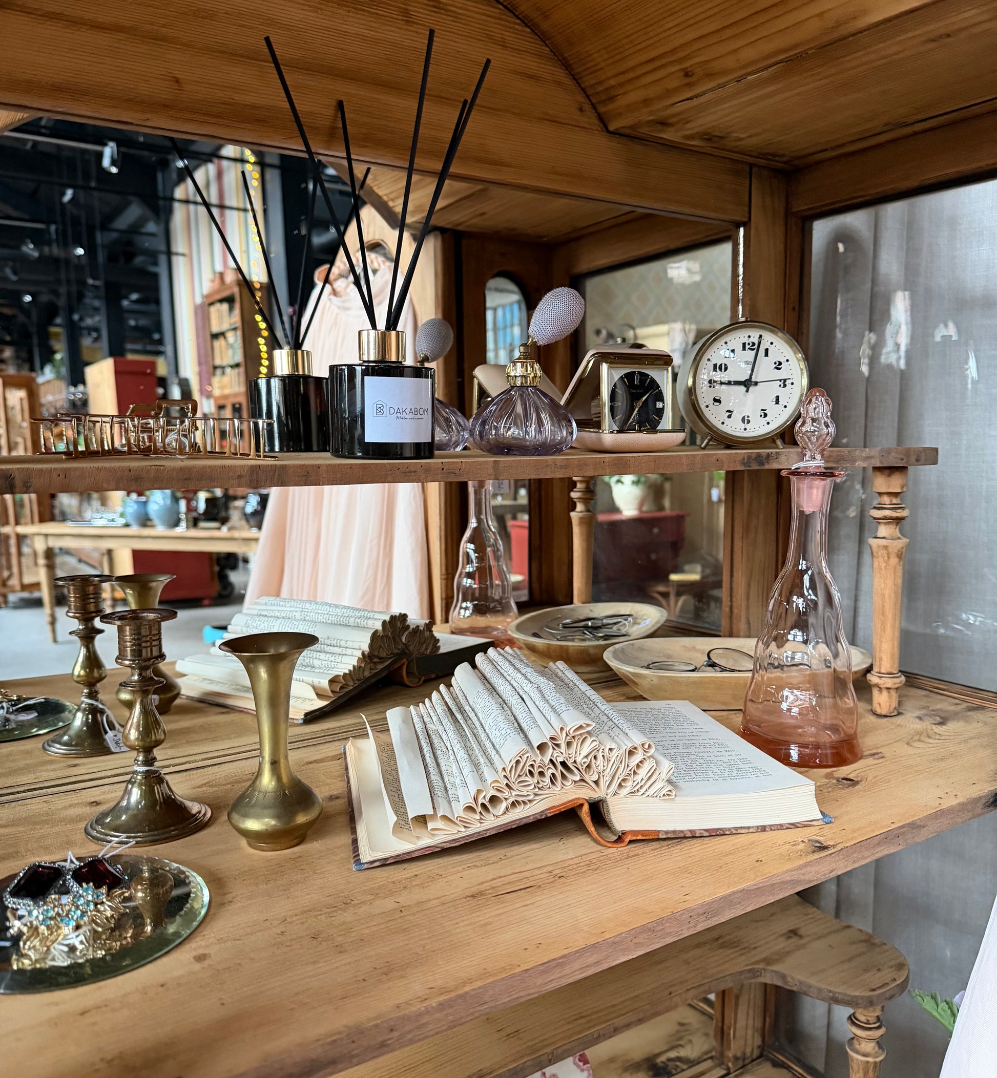 Ett gammalt, elegant vitrinskåp/displayskåp med ett stort glas samt glas i sidan för vackert ljusinsläpp. På skåpets insida sitter en spegel. 